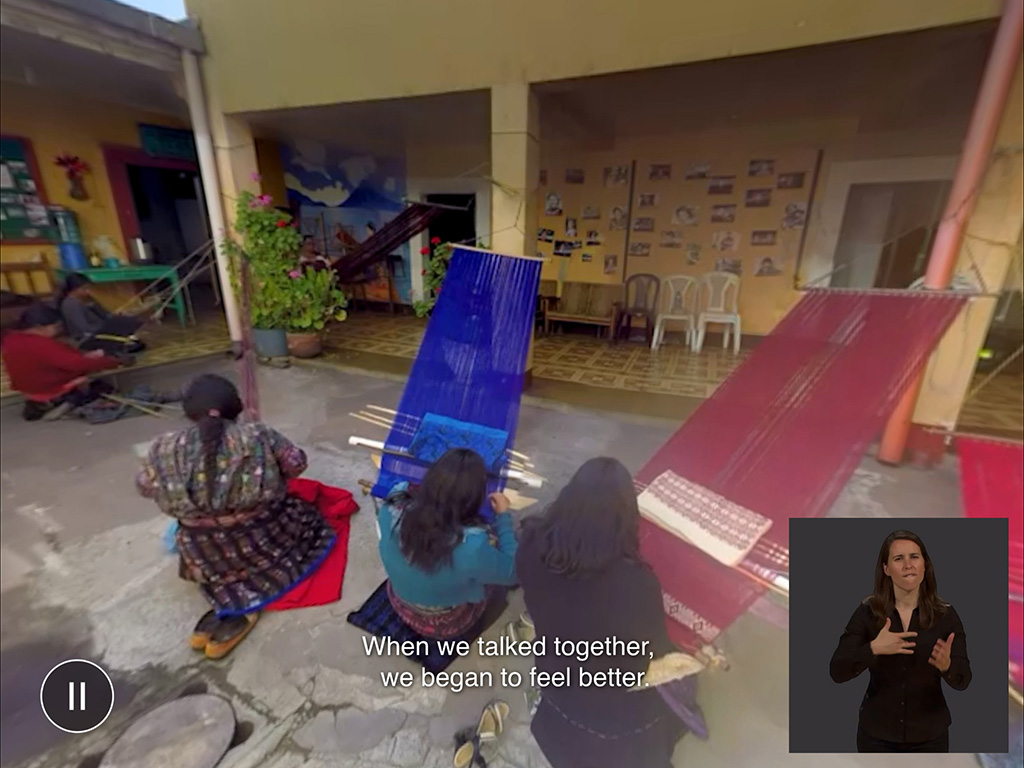 Outdoor scene of women weaving with sign language interpreter in the lower right of the screen.
