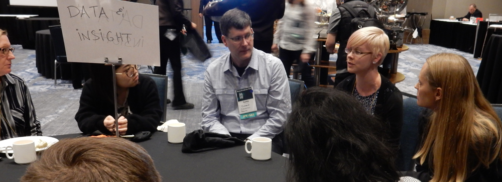 A group of MW17 attendees talk at a table during the birds of a feather breakfast.